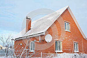 Brick house with metal roof covered snow after night snowstorm