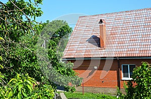 Brick house with metal roof damaged paint color by sun in the garden