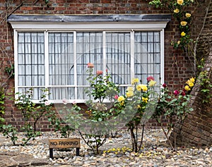 A brick house with roses on the front porch, seen in Rye, Kent, UK.