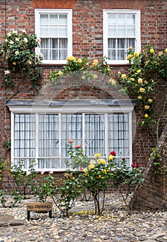 A brick house with roses on the front porch, seen in Rye, Kent, UK.