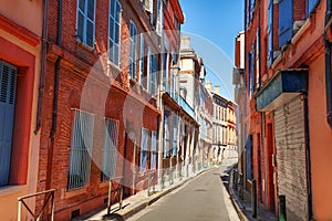 Brick houses on narrow street of Toulouse, France photo