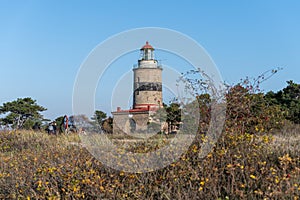 A brick lighthouse with a bright blue sky in the background. Picture of Falsterbo Lighthouse from 1796 in Scania