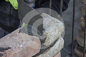 Brick mason using trowel to spread a mortar