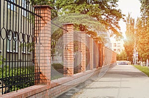 Brick and Metal Fence with Door and Gate of Modern Style Design In the setting sun. Metal Fence Ideas