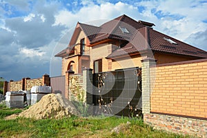 Brick and Metal Fence with Metal Gate of Modern Style Design Decorative Cracked Brick Wall with New House Construction Exterior.