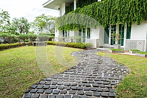 A brick paved road stretches into the garden