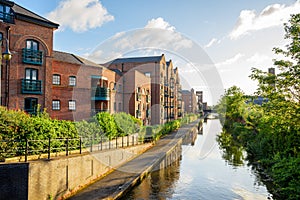 Brick residential buildings along a canal at sunset