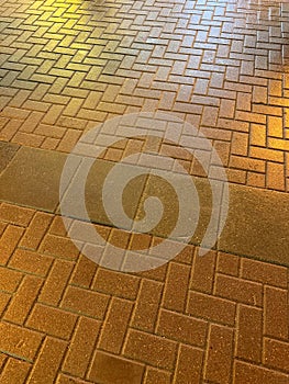 A brick sidewalk with a shiny, reflective surface