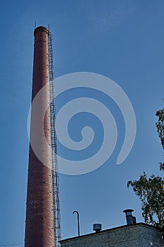 Brick smoke stack against the blue sky.