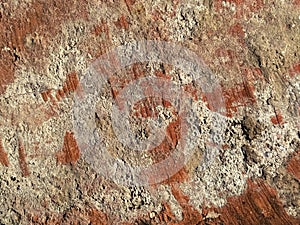 Brick or stone close-up. Texture or background. Bright red, brown, orange, beige colors. Dust, small pebbles, sand, soil and moss