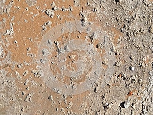 Brick or stone close-up. Texture or background. Bright red, brown, orange, beige colors. Dust, small pebbles, sand, soil and moss