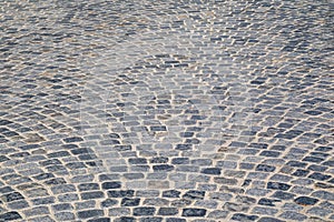 Brick stone street pavement close up background. Empty dark stone pavement on old town ancient street