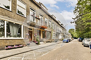 a brick street with cars parked in front of houses