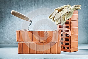 Brick trowel and gloves on concrette background