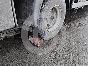 Brick under car wheel parking on slop way.Bad brakes on the truck.