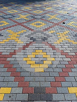 A brick walkway with a yellow and red pattern on it