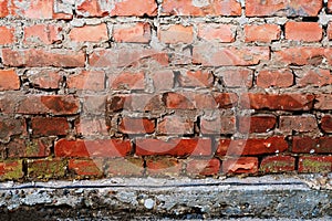 Brick wall background with concrete slub beneath photo