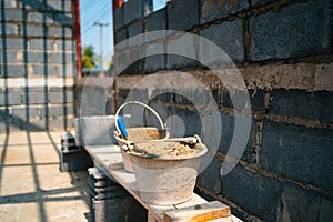 brick wall with a bucket of cement