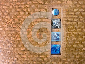 Brick wall with colored glass brick as windows in a rustic house wall