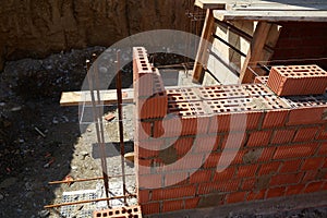 Brick wall construction in progress at a building site during daylight hours