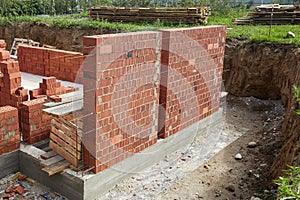 Brick wall construction in progress at a building site during daylight hours
