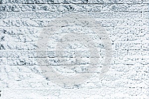 Brick wall covered with light blue snow. Iced winter surface texture. Copyspace for product placement or text