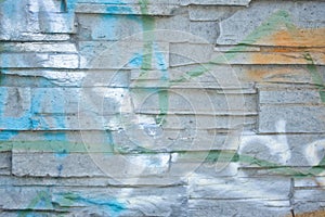 The brick wall is covered with old peeling plaster, painted in different colors.