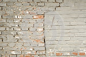 A BRICK WALL WITH CRACKING