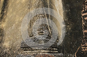 Brick wall with fretwork in the form of the head of a mythical c