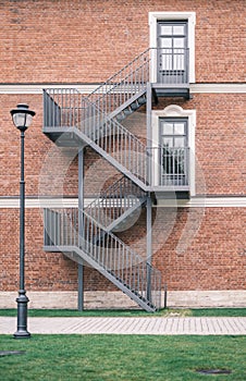 Brick wall with iron staircase and vintage windows.