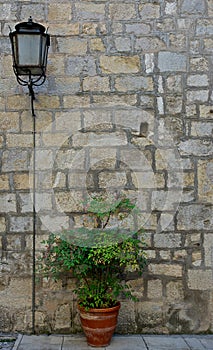 Brick wall with a lamppost and a flower pot photo