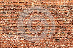 Brick wall made of old crumbling red bricks