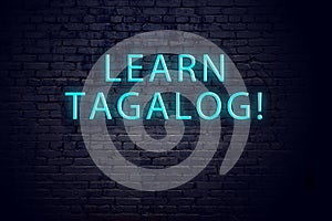 Brick wall and neon sign with inscription. Concept of learning tagalog photo