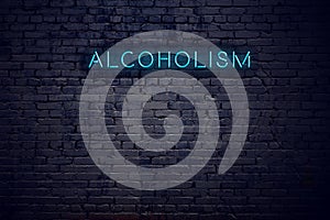Brick wall and neon sign with text alcoholism