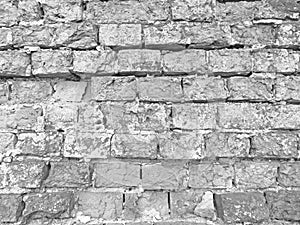 Brick wall. Old flaky white paint peeling off a grungy cracked wall. Cracks, scrapes, peeling old paint and plaster on background