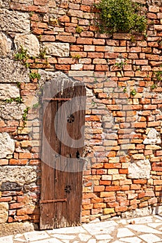 Brick wall of old house with a wooden door