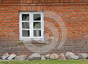 Brick wall of old house with wooden muntin window