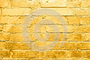 Brick wall painted in gold, golden graffiti background