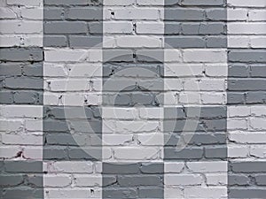 Brick wall painted in gray and white in checkerboard pattern