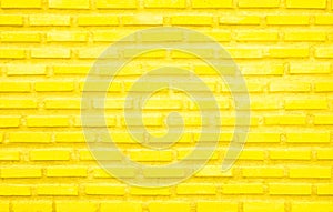 Brick wall painted with yellow paint pastel bright tone texture background. Brickwork and stonework flooring interior with rock