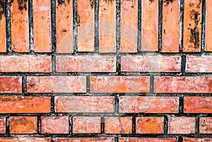 Brick wall with red bricks Red, orange brick background, arranged in complex horizontal rows in layers interlocked with cement.