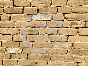 Brick wall of red-orange bricks and blocks. Lightly worn surface. Neat masonry, cement between the rows. Grunge background.