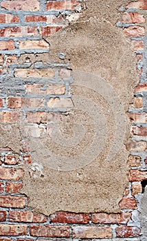 Brick wall with sandy patch