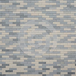 A brick wall with a staggered pattern composed of alternating gray and beige