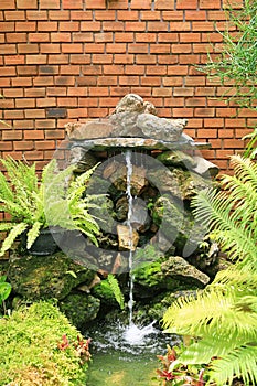 Brick wall stones and little water fall in garden