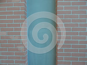 Brick wall with turquoise awork in the middle