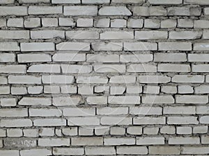 A brick wall of white old broken bricks.