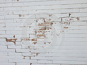 Brick wall with white peeling paint