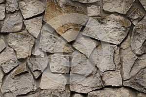 Brick wall of a wild stone close up background. Gray ancient texture of stone