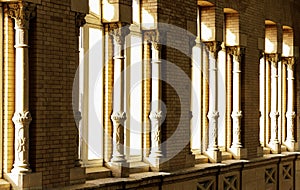 Brick wall with windows adorned with columns through which sunlight enters. Atocha station, Madrid